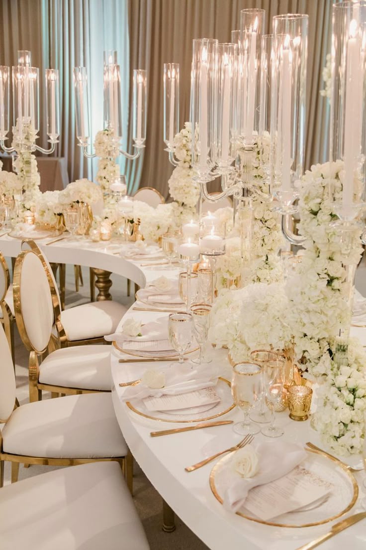 Gold candelabras and ivory florals lining a long banquet table